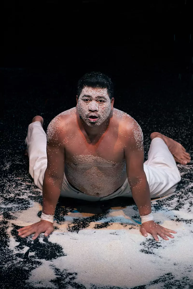 Un intérprete en Phare Circus en Siem Reap con arroz pegado a su cara y cuerpo.