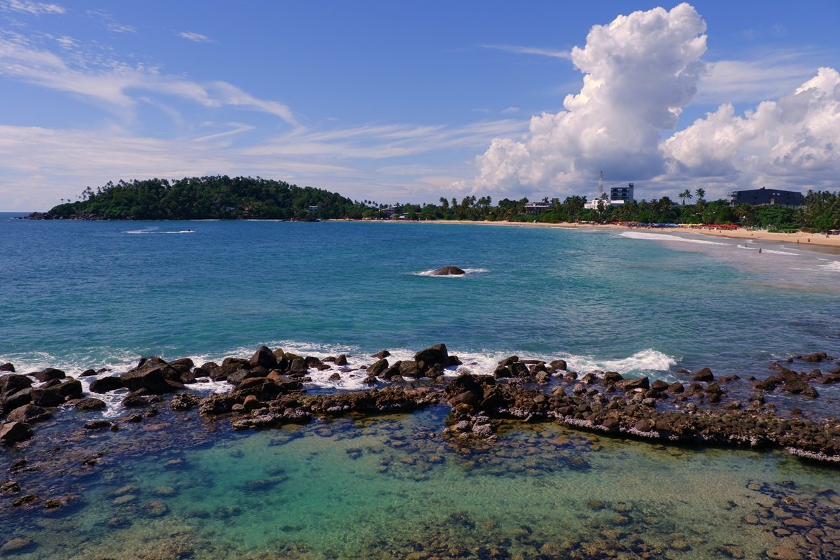 Un banco rocoso en Mirissa Beach en Sri Lanka con hermosas aguas azules claras.