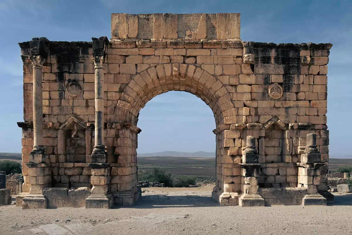 Un arco bien conservado y rodeada en la ruina romana de Volubilis, Marruecos.